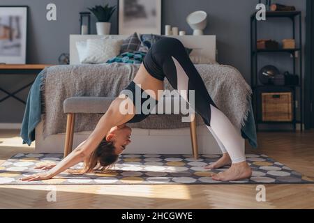 Fitness woman practising downward facing dog yoga pose Stock Photo