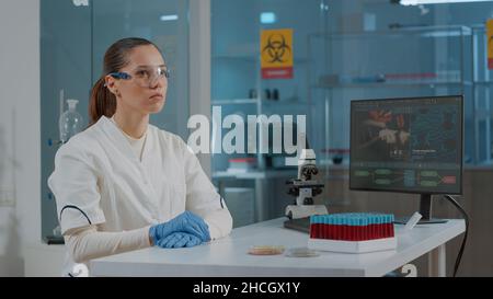 Lab worker using glasses with virtual reality to develop experiment, working with vr goggles to analyze 3d projection for futuristic development in laboratory. Digital presentation Stock Photo