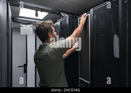 IT engineer working In the server room or data center The technician puts in a rack a new server of corporate business mainframe supercomputer or Stock Photo