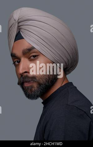 Calm bearded mustached man in the head wrap staring ahead Stock Photo