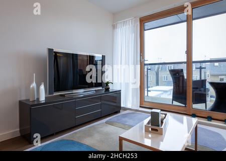 Cambridge, Cambridgeshire, England - Jan 18 2013: Modern stylish open plan living room within vacant show home with sliding glazed doors opening to ba Stock Photo