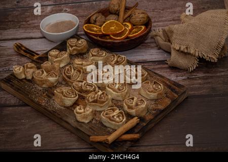 cinnamon and brown sugar rolls ready for baking on a wooden board Stock Photo
