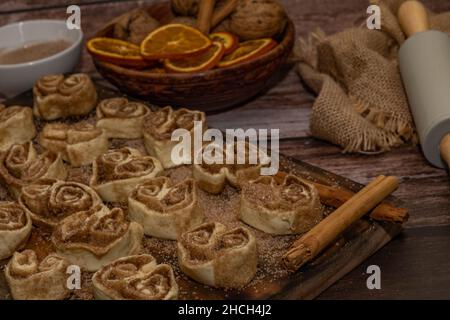 cinnamon and brown sugar rolls ready for baking on a wooden board Stock Photo