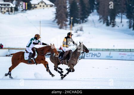 Santiago Marambio (white) of Team Azerbaijan Land of Fire chases Nic Roldan (black) of Team Badrutt's Palace Hotel, 36th Snow Polo World Cup St. Stock Photo