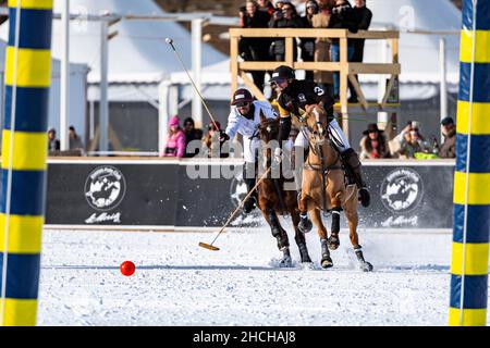 Nic Roldan (black) of Team Badrutt's Palace Hotel fights for the ball in front of the goal against Adrian Laplacette jr. (white), 36th Snow Polo Stock Photo