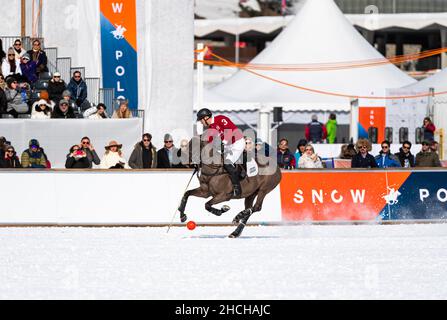 Spectators watch Max Charlton of Team St. Moritz galloping across the field with the red ball, 36th Snow Polo World Cup St. Moritz 2020, Lake St. Stock Photo