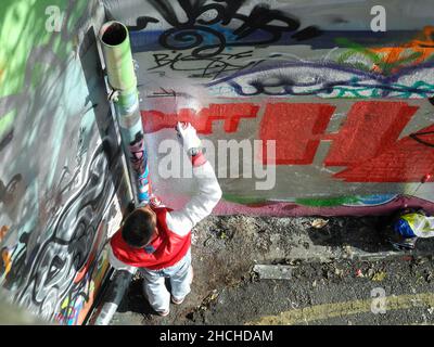 A birds-eye view young man spray-painting graffiti in Leake Street, Waterloo, England, U.K. Stock Photo