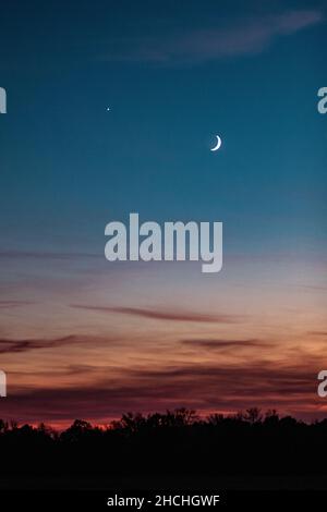 Vertical shot of a moon in a sunset sky over Wisconsin Stock Photo