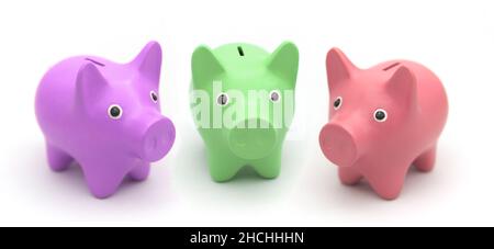Piggy banks of different colors on a white background form a circle around the camera Stock Photo