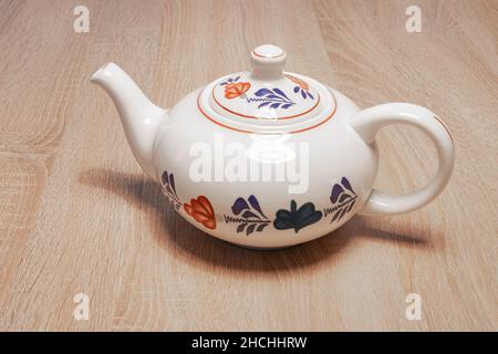 Traditional Dutch teapot with a hand-painted farmer's pattern ('boerenbont') on a wooden table. Stock Photo
