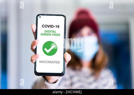 Green pass of the covid-19, a woman shows a mobile phone with the health passport. Vaccination certificate to enter bars and restaurants or nightlife, Stock Photo