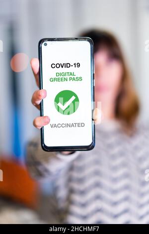 Green pass of the covid-19, a woman shows a mobile phone with the health passport. Vaccination certificate to enter bars and restaurants, coronavirus Stock Photo