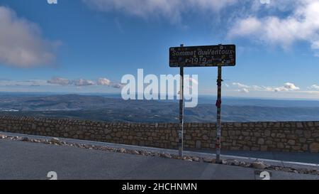 View of signpost on the peak of popular Mont Ventoux ('windy mountain'), Provence, France with stone wall and panoramic view. Stock Photo