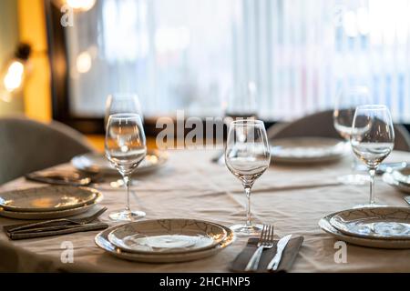 Shallow focus beautiful table setting with crockery and glasses for an event in the restaurant Stock Photo