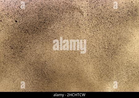 black spray paint on gold colored paper Stock Photo
