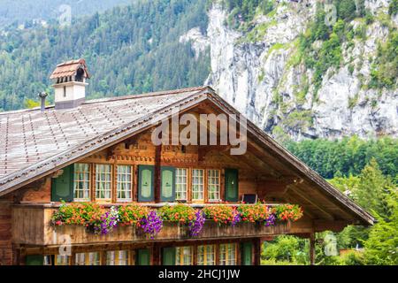 Swiss architecture wooden house with summer flowers in Lauterbrunnen valley, Switzerland, Europe Stock Photo