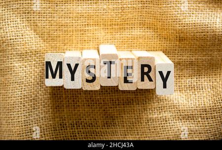 Mystery symbol. The concept word Mystery on wooden blocks. Beautiful canvas background, copy space. Business and mystery mysterious concept. Stock Photo
