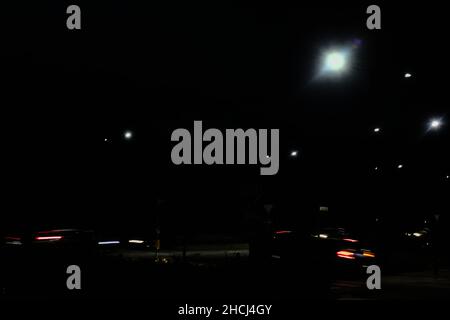 Cars passing on a roundabout at night Stock Photo