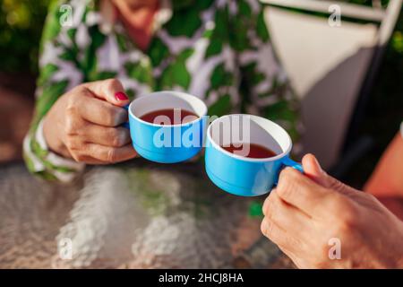 Senior family couple drinking tea in cafe. People enjoying beverages outdoors. Close-up of cups Stock Photo