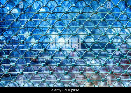 Closeup shot of a metal grid against a blue background on a sunny day Stock Photo