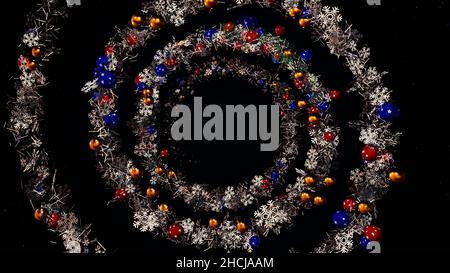 Abstract beautiful spiral, Christmas garland with toys and tinsel, seamless loop. Spinning silver and green vortex with colorful New Year tree decorat Stock Photo