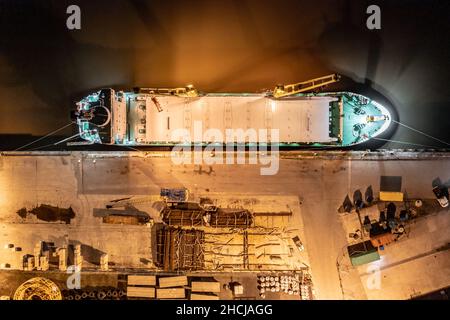 Ship Offloading Cargo at Docks at Night Stock Photo