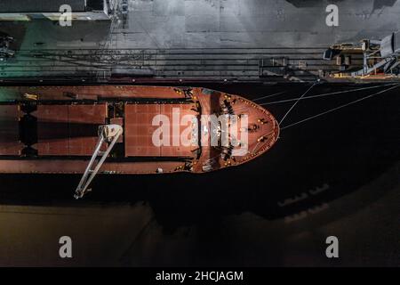 Ship Offloading Cargo at Docks at Night Stock Photo