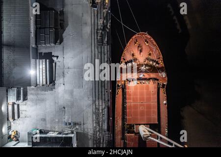 Ship Offloading Cargo at Docks at Night Stock Photo