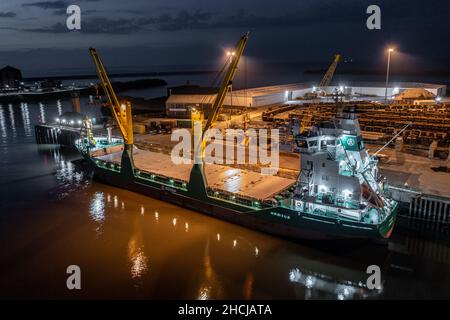 Ship Offloading Cargo at Docks at Night Stock Photo