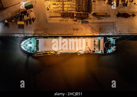 Ship Offloading Cargo at Docks at Night Stock Photo