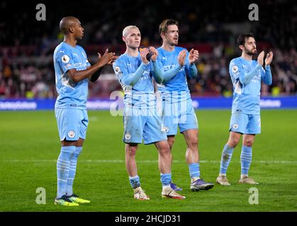 Manchester City's Fernandinho (left), Phil Foden, Jack Grealish and Bernardo Silva applaud the fans at the end of the Premier League match at the Brentford Community Stadium, London. Picture date: Wednesday December 29, 2021. Stock Photo