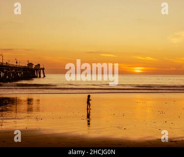 Silhouette shot of a baby running on the sand at San Clemente seashor Stock Photo