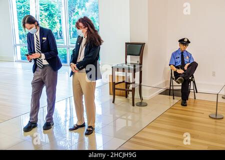 Vero Beach Florida Museum of Art VBMA collection exhibit exhibits inside interior artwork human figure security guard guards male female wearing face Stock Photo