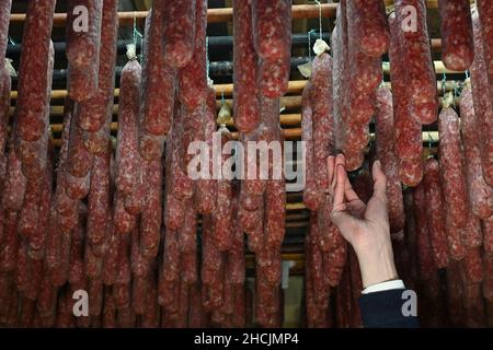 Calden, Germany. 27th Dec, 2021. Ahle sausages hang from the ceiling in the sausage heaven of the Henry Koch country butchery. The company has been producing the air-dried mead sausage, which has its origins in the house slaughtering that used to be common, since 1877. In the sausage heaven, a chamber surrounded by clay walls, the sausages mature for between four weeks and twelve months. (to dpa: 'Northern Hesse's 'Ahle Wurst': Cult object between tradition and innovation') Credit: Uwe Zucchi/dpa/Alamy Live News Stock Photo