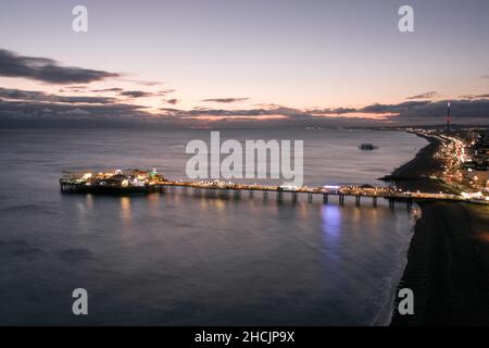 The Seafront Palace Pier in Brighton Illuminated at Night Aerial View Stock Photo