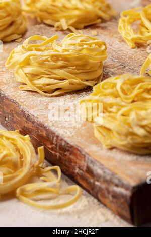 Fresh tagliatelle nests pasta on wood Stock Photo