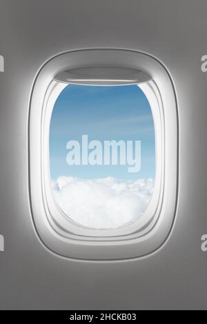 looking through a big jet passenger plane window, above the clouds Stock Photo