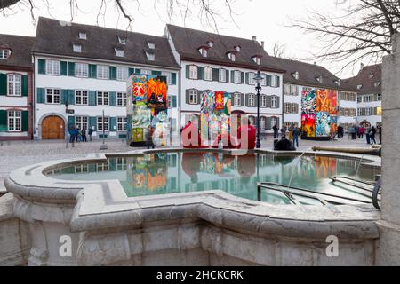 Basel, Switzerland - February 21. Carnival revellers in red costumes at the fountain on the cathedral square Stock Photo