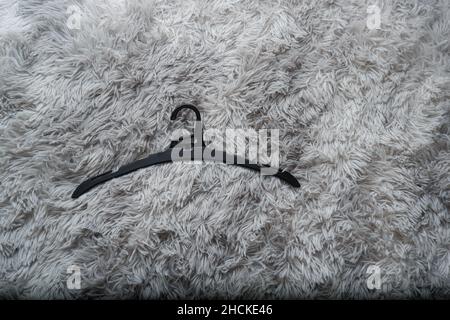 Single empty black hanger on gray background Stock Photo
