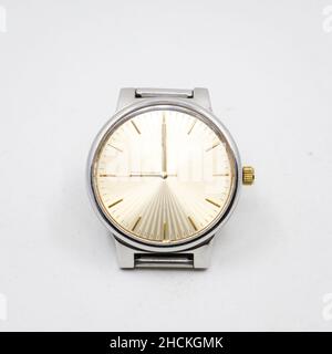 a silver stainless steel analog watch with a round golden dial made as a vintage luxury symbol isolated in a white background Stock Photo