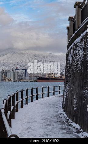 Seawall path in overcast winter day, the curved lines of the path around Stanley Park with the waters of the Pacific Ocean. Vancouver BC, Canada. Stre Stock Photo