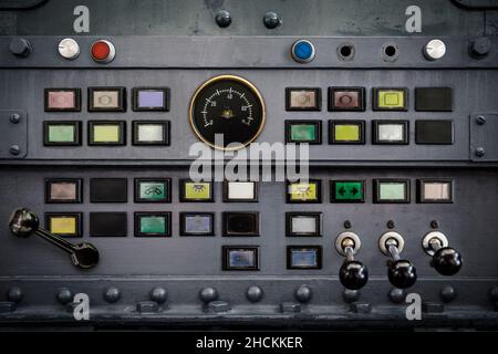 Old switches, buttons, and levers on a metal panel as a background for industry. Stock Photo