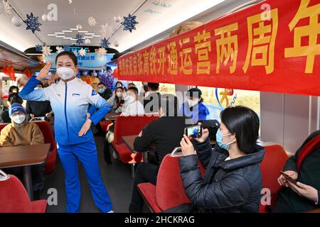 (211230) -- BEIJING, Dec. 30, 2021 (Xinhua) -- A crew member performs on a train of the Beijing-Zhangjiakou high-speed railway on Dec. 30, 2021. The high-speed railway connecting Beijing and Zhangjiakou in north China's Hebei Province went into service on Dec. 30, 2019. (Xinhua/Huang Zhen) Stock Photo