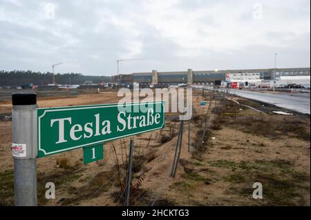 30 December 2021, Brandenburg, Grünheide: At an access road to the future Tesla Gigafactory Berlin Brandenburg, a street sign reads 'Tesla Straße 1'. According to the Brandenburg state government, Tesla has submitted the missing documents for the approval process. Photo: Christophe Gateau/dpa Stock Photo