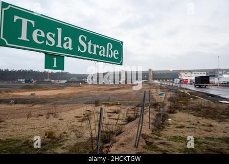 30 December 2021, Brandenburg, Grünheide: At an access road to the future Tesla Gigafactory Berlin Brandenburg there is a street sign with the inscription ''Tesla Straße 1''. According to the Brandenburg state government, Tesla has submitted the missing documents for the approval process. Photo: Christophe Gateau/dpa Stock Photo