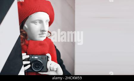 plaster statue in a red beret and scarf with a camera in his hands. Photography art symbol. High quality photo Stock Photo