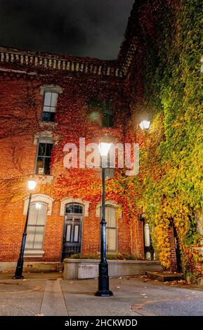 Bright street light next to a red residential brick building at night Stock Photo