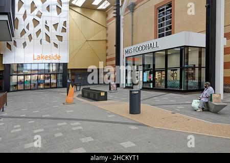 M&S Food Hall at Lakeside shopping center entrance doors & sign with access to Marks and Spencer retail store alone shopper wearing Covid face mask UK Stock Photo