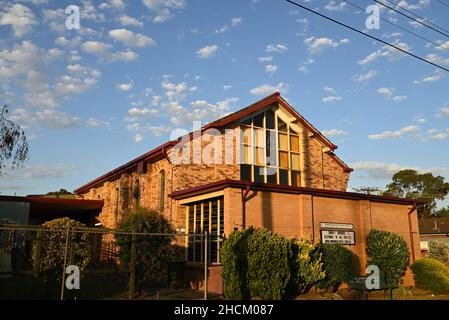 Ormond Community Church of Christ, on North Rd, its stained glass windows illuminated by the setting sun Stock Photo