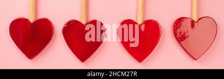flat lay of heart-shaped lollipops isolated on pink, banner Stock Photo